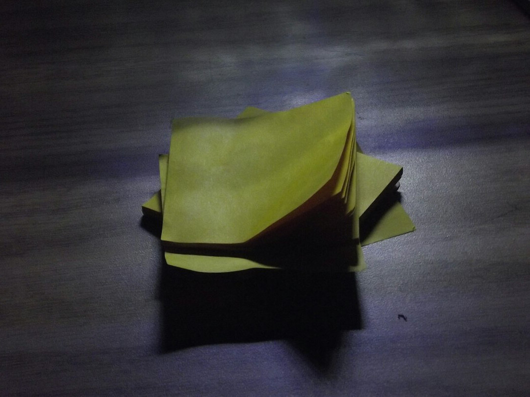 Open notebook with pen on a wooden desk near a laptop