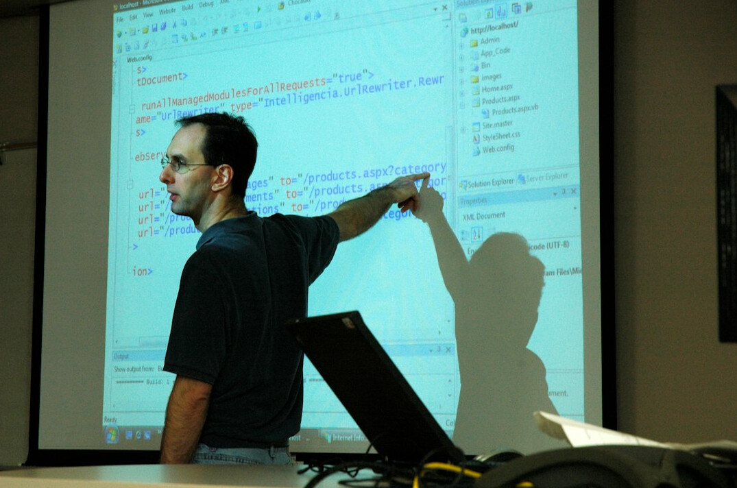 Mentor guiding a colleague at a whiteboard